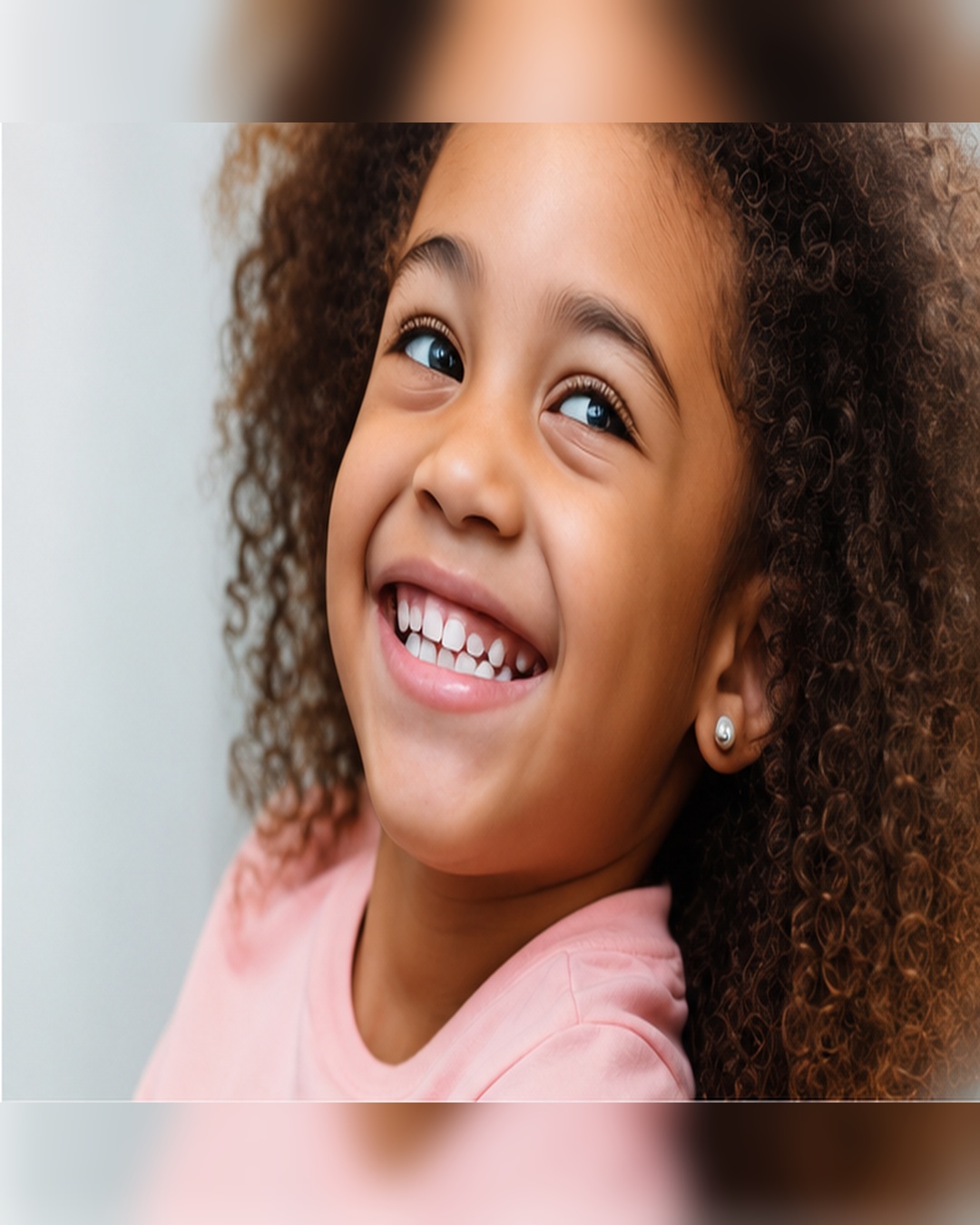Menina sorrindo, mostrando os dentes de leite